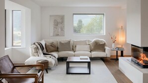 Una sala de estar moderna con sofá, mesa de centro y chimenea.