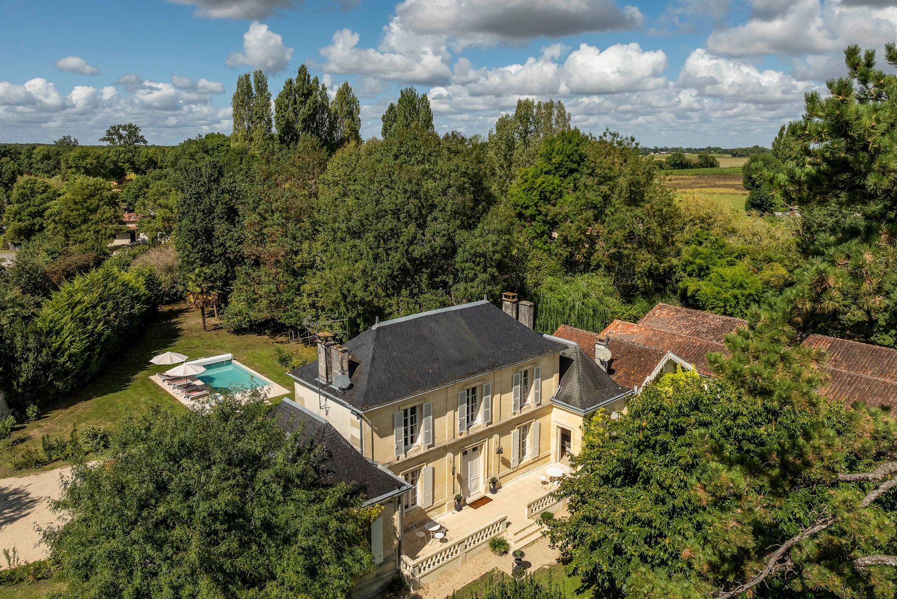 A large, two-story house with a swimming pool and a garden.
