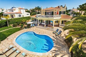 A large, curved swimming pool with lounge chairs and a covered patio area. - Villa Palmeira - Four Bedroom Villa, Sleeps 8 (Carvoeiro)