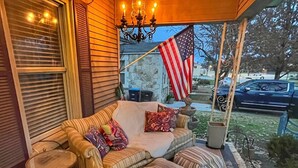 Een gezellig terras met zachte zitplaatsen, een kleine tafel en een decoratieve Amerikaanse vlag.