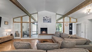 A spacious living room with a fireplace, a large sofa set, and a wooden coffee table. - Its not Unusual MidTerm Rental (Arlington)