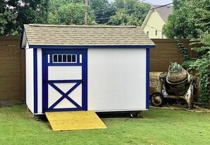 A small shed with a blue door and a ramp leading up to it. - Vintage Charming 1-bedroom house with WiFi and AC in welcoming Fort Worth. (Fort Worth)