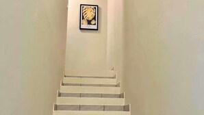 A staircase leading up to a framed picture on the wall.