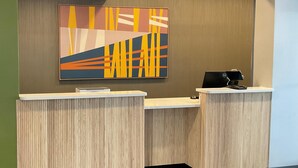 A reception desk with a modern design, featuring a wooden finish and a built-in computer monitor. - Clemmons inn & suites (Clemmons)