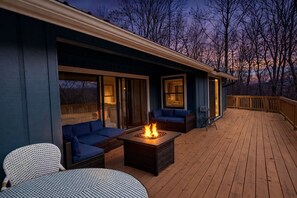 A deck with a fire pit, seating, and a view of the sky. - Lazy Lake Dayz: Modern Rumbling Bald Resort Oasis w/Golf Views, Fire Pit & Games (Lake Lure)