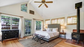 Un dormitorio con cama, cómoda y chimenea.