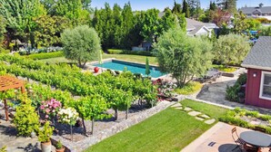 Ein Garten mit Pool, einer Pergola und einer Terrassenfläche.