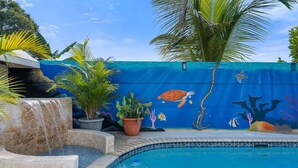 Une piscine dont l’un des murs est décoré d’une fresque représentant la vie marine.