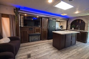 A modern kitchen with a built-in oven, a large island, and a stone archway. - RIncon Camper Retreat (Rincón)