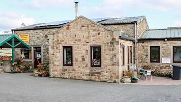 Un edificio de piedra con toldo verde que dice "Riber View Fresh Farm Produce".