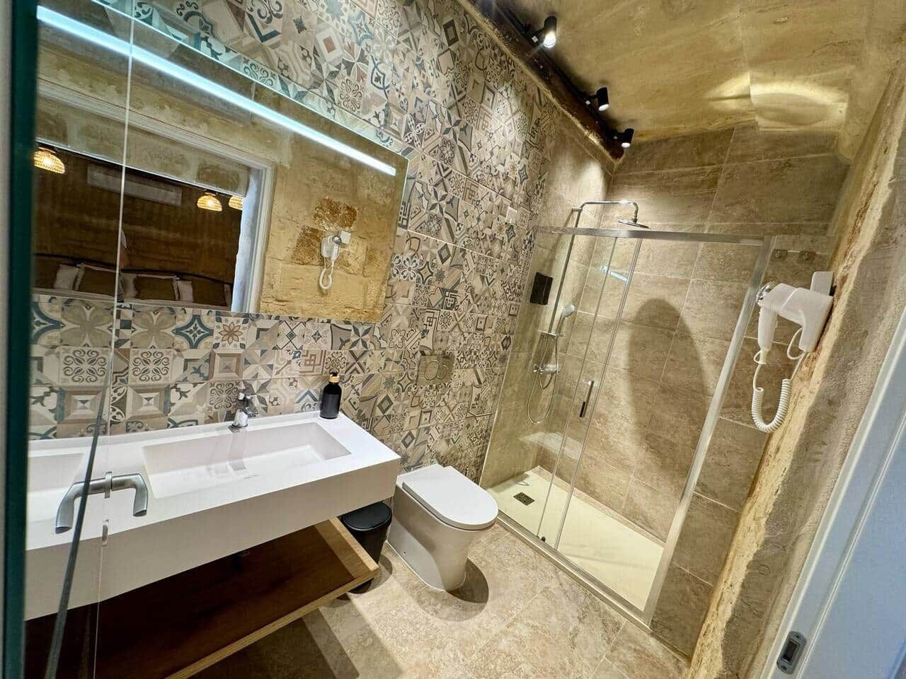 Une salle de bain moderne avec un grand lavabo, des toilettes et une douche à parois de verre.