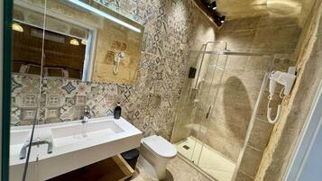 Une salle de bain moderne avec un grand lavabo, des toilettes et une douche à parois de verre.