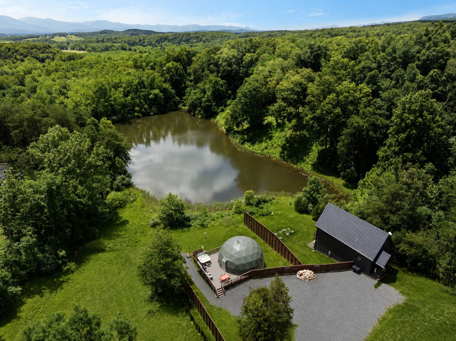 Una propiedad junto al lago con un estanque grande, un pabellón y una cabaña.