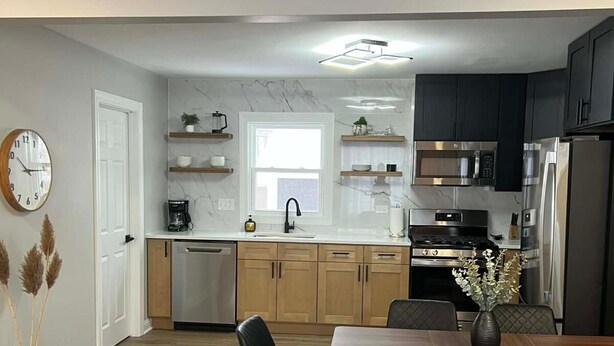 A modern kitchen with dark cabinets, stainless steel appliances, and wooden countertops. - Modern 3BR Home Near Wheaton College & Cantigny (Wheaton)