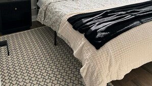 A modern bedroom with a bed, a bedside table, a floor lamp, and a decorative wall piece. - Modern 3BR Home Near Wheaton College & Cantigny (Wheaton)