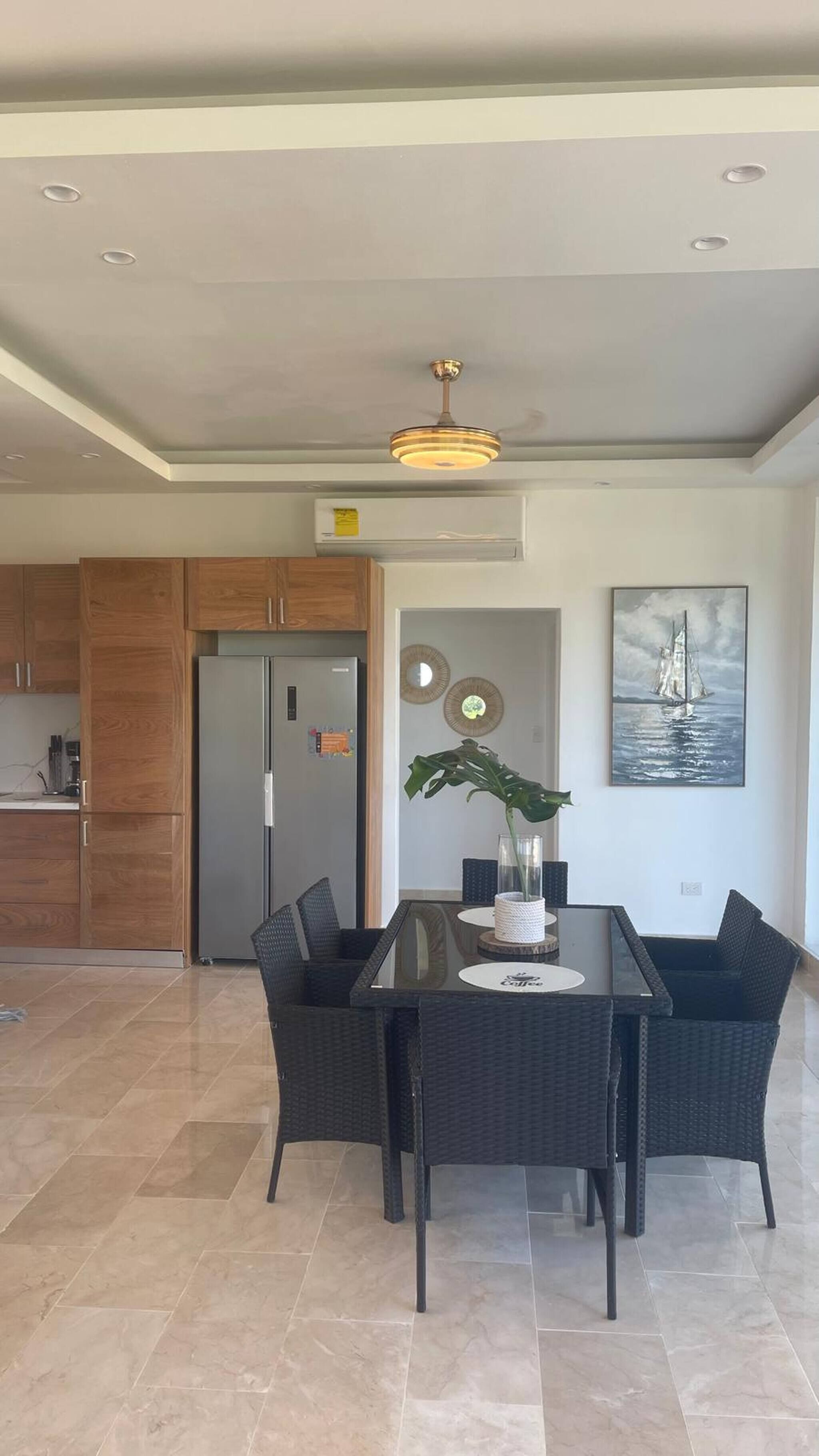 A modern kitchen with wooden cabinets and a stainless steel refrigerator.