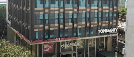 A multi-story building with a modern design, featuring a prominent "ibis Hotel" sign at the top.