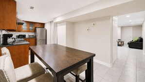 Una cocina moderna con armarios de madera, electrodomésticos de acero inoxidable y una mesa de comedor con sillas.