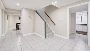 Un pasillo amplio con una escalera que conduce a una zona de cocina.