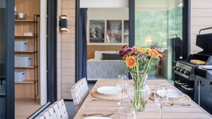 A dining table set with plates, cutlery, and a vase of flowers. - Ridgeline Penthouse (Revelstoke)