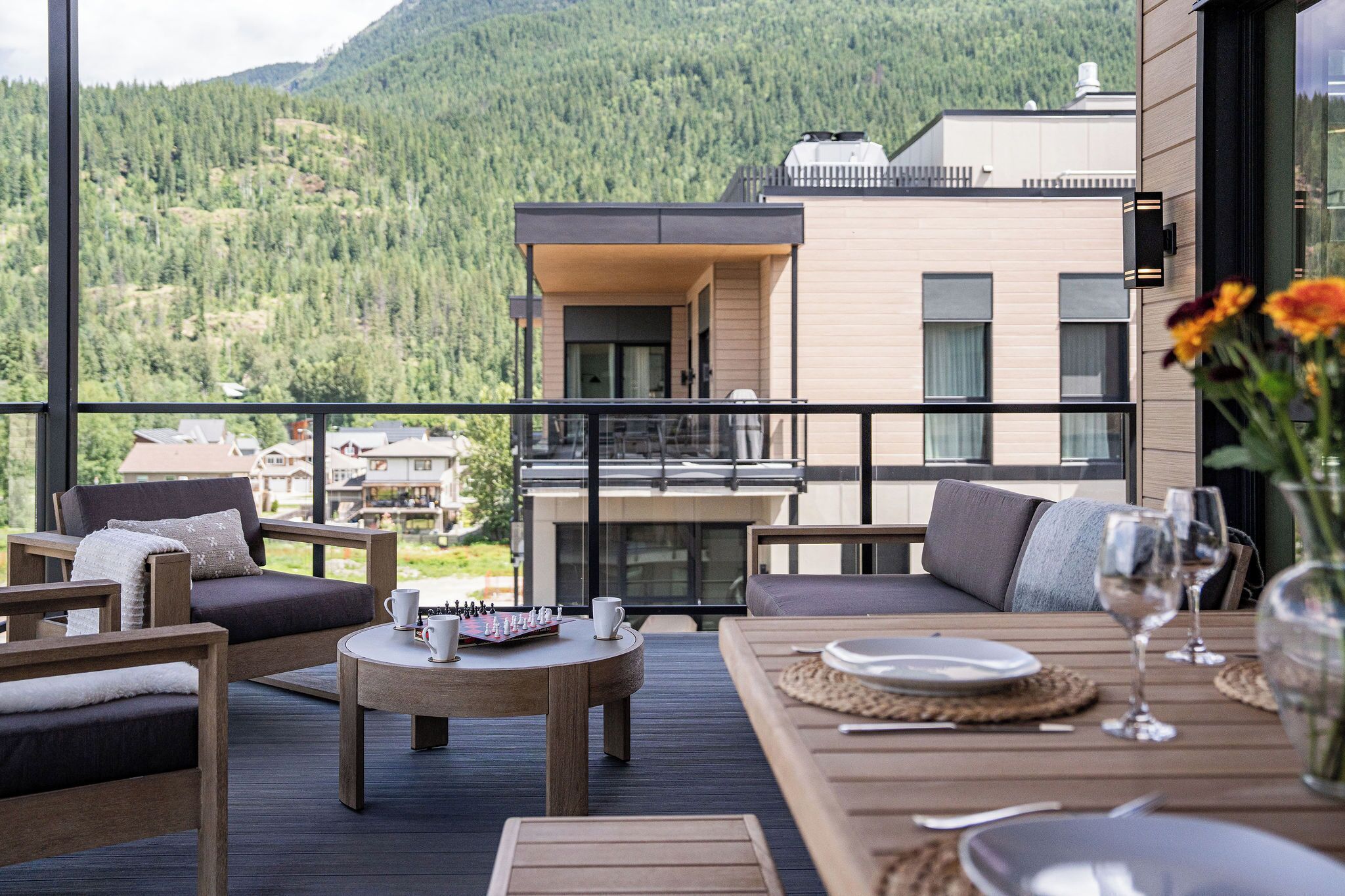A balcony with outdoor furniture, a chessboard, and a dining setup.