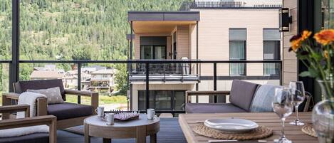 A balcony with outdoor furniture, a chessboard, and a dining setup.