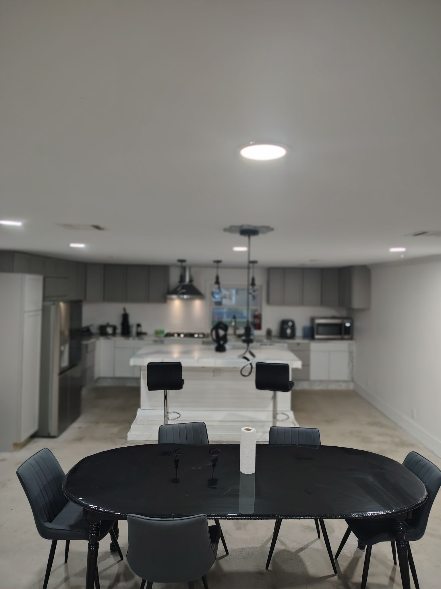 Une cuisine moderne dotée d’un îlot central, d’une table à manger et de chaises.