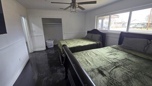 A bedroom with two beds, a ceiling fan, a window, and a closet. - Peaceful 3-bedroom house with AC in charming Jennings (Jennings)