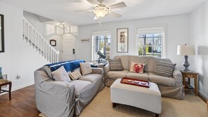 A living room with a ceiling fan, two couches, a coffee table, and a staircase. - 2 min walk to BEACH! 4 Bdrm/outdoor shower (Kennebunkport)
