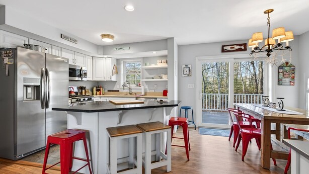 A modern kitchen with a large island, stainless steel appliances, and red bar stools. - 2 min walk to BEACH! 4 Bdrm/outdoor shower (Kennebunkport)