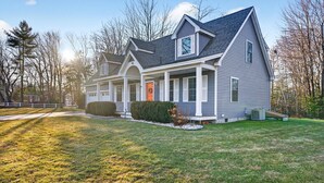 A two-story house with a front porch, a covered entryway, and a well-maintained lawn. - 2 min walk to BEACH! 4 Bdrm/outdoor shower (Kennebunkport)