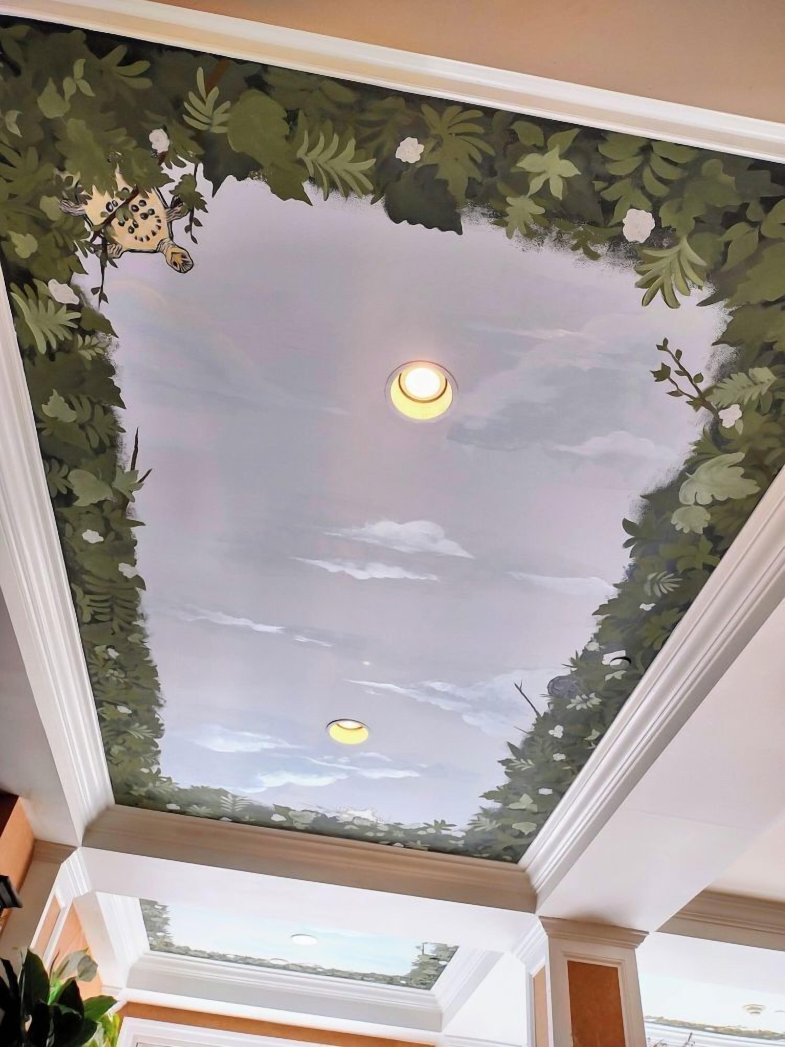 Plafond met een schilderij van een lucht en bladeren, inbouwverlichting en een uitzicht op de omgeving door een dakraam.