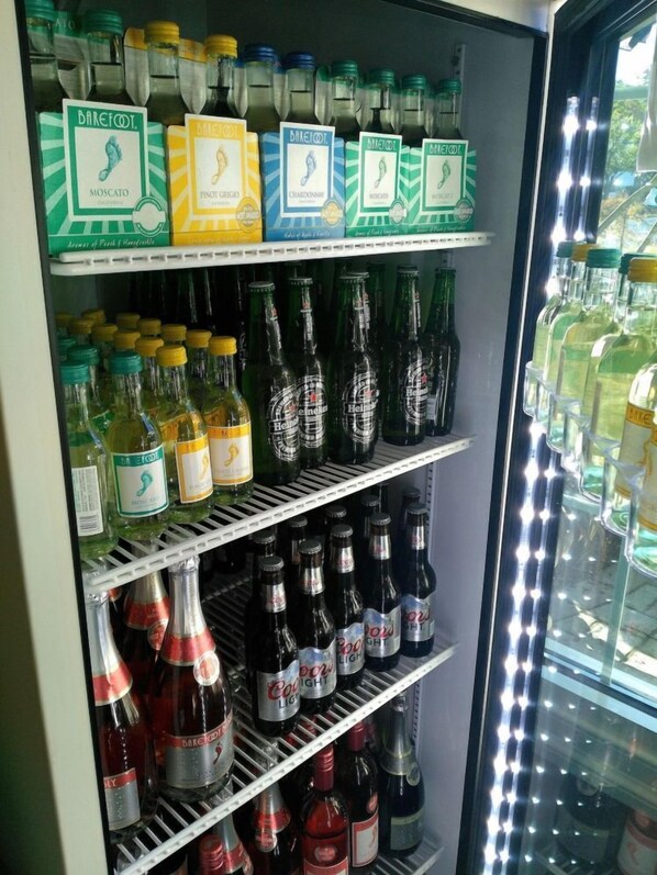 A refrigerated display case with various beverages including Barefoot wines and Heineken beer.