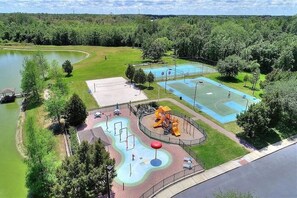 Ein Park mit Basketballplatz, Spielplatz und einem kleinen Teich.
