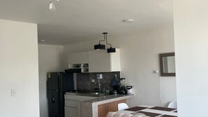 Una sala moderna con un sofá color beige y un ventilador de techo.