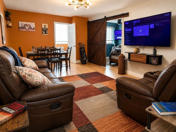A living room with leather sofas, a TV, and a dining area. - Downtown Atlanta 3BR Condo • Near Stadium & Arena (Atlanta)