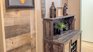 A wall with a sign that reads 'EMPTY R. REPEAT' and another sign that says 'Wine Cellar.' There are bottles on a shelf above the wall. - Downtown Atlanta 3BR Condo • Near Stadium & Arena (Atlanta)