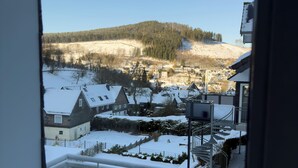 Schneelandschaft mit Häusern und einer Hügelkulisse.