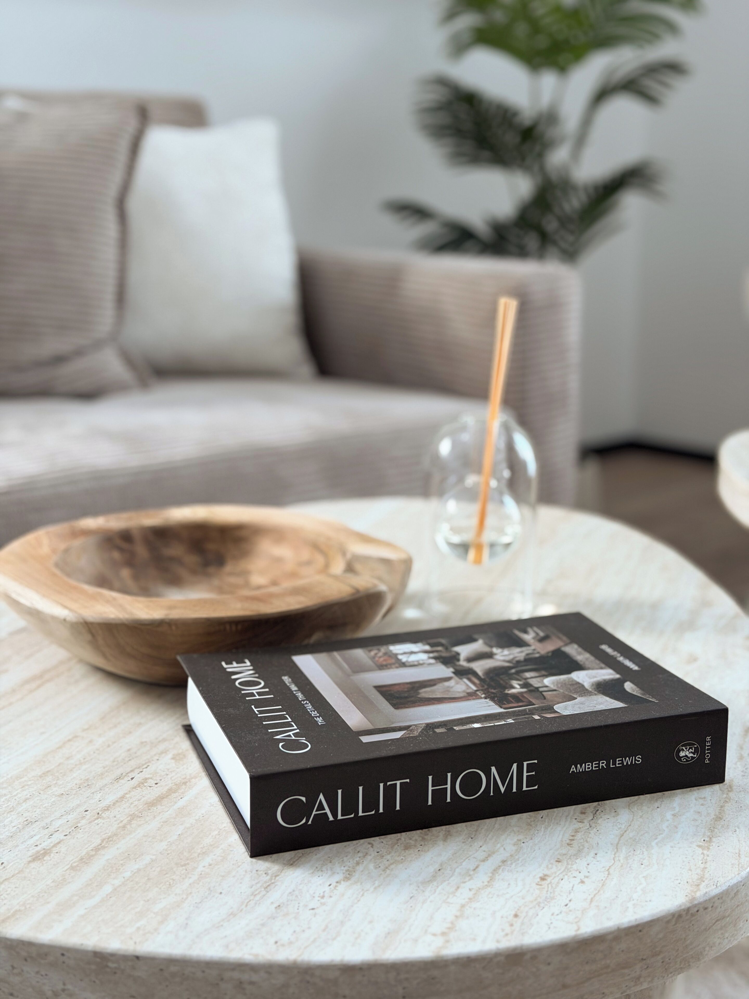 A book titled 'Callit Home' by Amber Lewis on a round marble table.