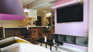 Un salon moderne avec un canapé, une table basse et un téléviseur fixé au mur.