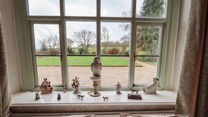 A bedroom with a large window overlooking a garden.