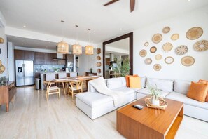 A modern living room with a sofa, coffee table, and dining area. - Above The Arch: Penthouse w/ Private Rooftop Pool (Cabo San Lucas)