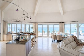 A spacious living area with a kitchen, dining area, and a large balcony with ocean views. - The Beachhouse At Rancho Leonero (Los Cabos)