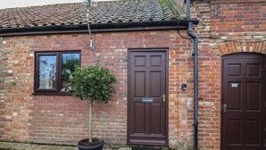 A brick building with two brown doors, one labeled "The Gun Room." - The Gun Room (Beccles)