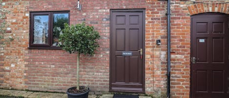 A brick building with two brown doors, one labeled "The Gun Room."