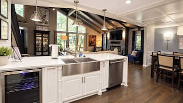 A spacious kitchen with a large island, built-in appliances, and a dining area with a wooden table and chairs.