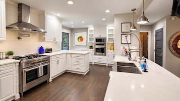 Una cocina moderna con armarios blancos, electrodomésticos de acero inoxidable y una isla central.