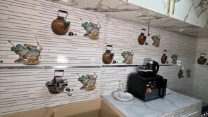 Una cucina moderna con zoccolo in marmo, lavello e diversi elettrodomestici.