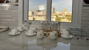 Una cucina con vista sulla città attraverso una finestra, un piano di lavoro in marmo e diversi utensili da cucina.