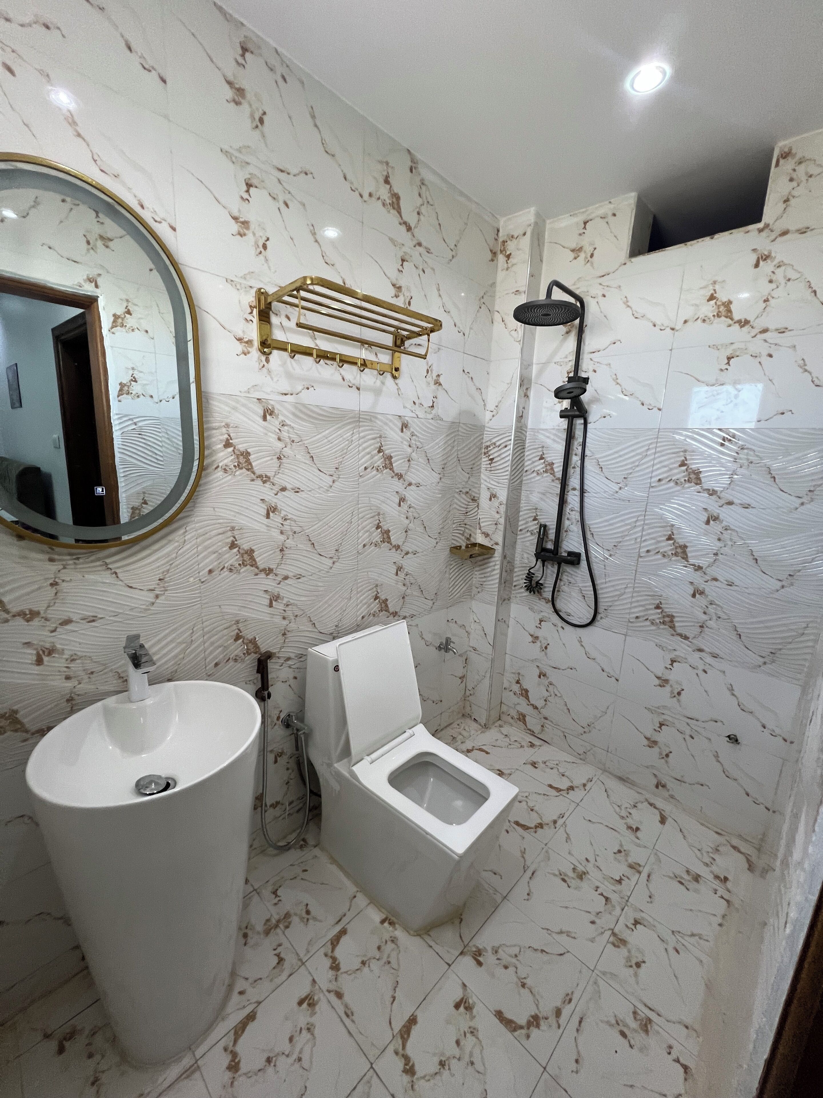 A bathroom with a toilet, sink, and shower.
